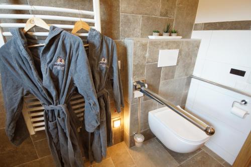 a bathroom with a toilet and a robe on the wall at Kaiserappartements-Marie in Ellmau
