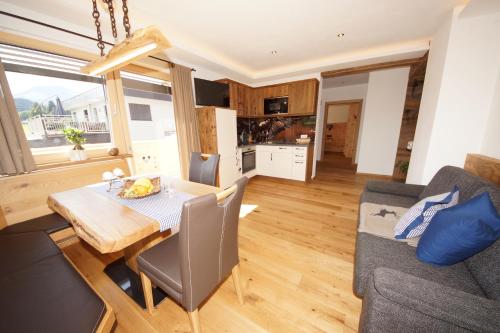 a kitchen and living room with a table and a couch at Kaiserappartements-Marie in Ellmau