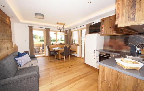 a kitchen and living room with a couch and a table at Kaiserappartements-Marie in Ellmau