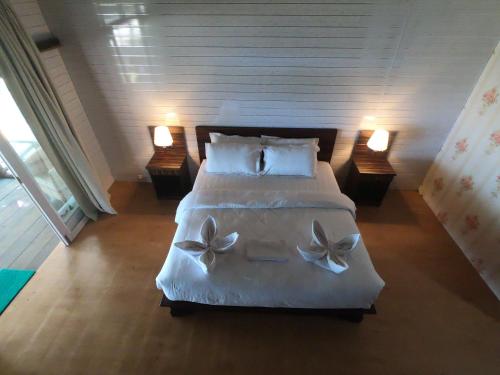 una camera da letto con un letto grande con lenzuola e cuscini bianchi di BatuRundung Surf Resort a Naibos