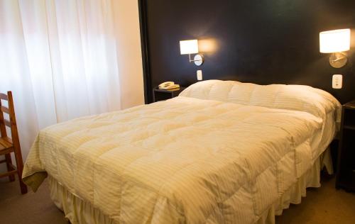 1 dormitorio con 1 cama con edredón blanco en Hotel Milton en La Paz