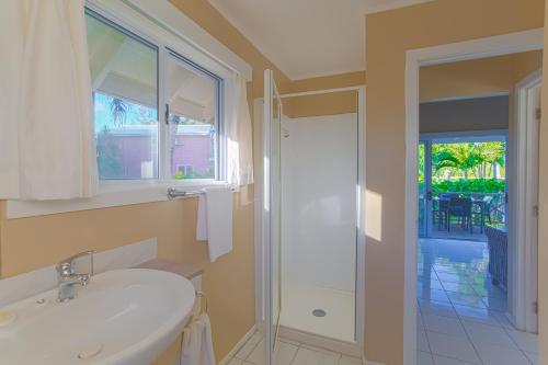 a bathroom with a white sink and a window at Manea on Muri in Rarotonga