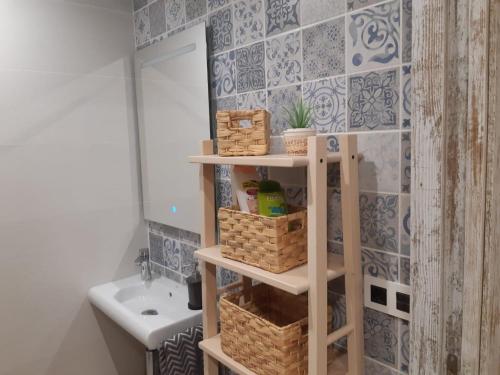 baño con estante con cestas y lavamanos en Cal Marsal en Aitona