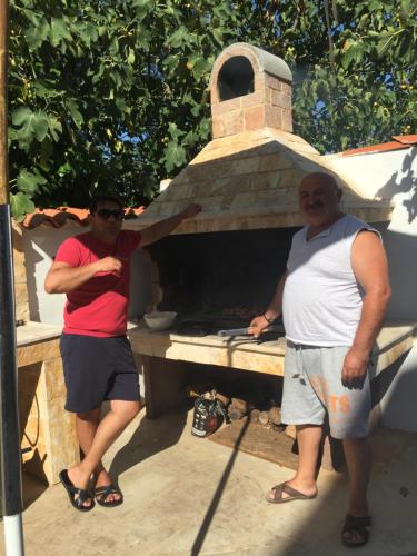 two men standing in front of a brick oven at Apartments Villa Mimi in Višnjan