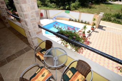 a patio with a table and chairs and a swimming pool at Apartments Villa Mimi in Višnjan