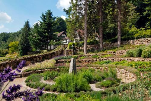 a garden with flowers and a stone wall at Gidleigh Park- A Relais & Chateaux Hotel in Chagford