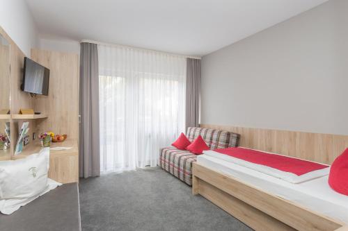 - une chambre avec un lit, un canapé et une fenêtre dans l'établissement Gasthof Restaurant Hirsch, à Bad Ditzenbach
