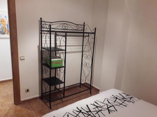 ログローニョにあるApartamento Logroñoのベッド1台と黒い鉄製の棚が備わる客室です。