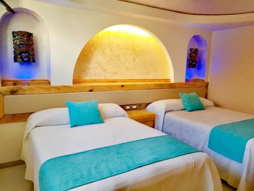two beds in a room with two arched windows at Hotel Blue Star Cancun in Cancún