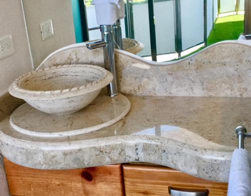 a bathroom with a stone sink and a toilet at Hotel Blue Star Cancun in Cancún