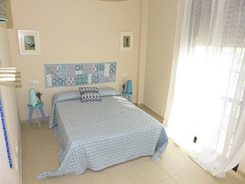 ヘレス・デ・ラ・フロンテーラにあるApartamento barrio San Miguelのベッドルーム1室(青と白の掛け布団付きのベッド1台付)