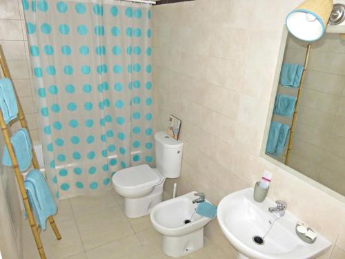 a bathroom with a toilet and a sink and a mirror at Apartamento barrio San Miguel in Jerez de la Frontera