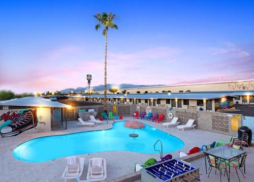 uma piscina num resort com cadeiras e mesas em Hotel McCoy - Art, Coffee, Beer, Wine em Tucson