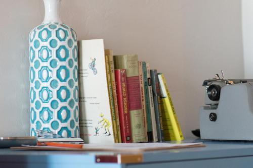 a group of books on a table with a vase at Hotel McCoy - Art, Coffee, Beer, Wine in Tucson