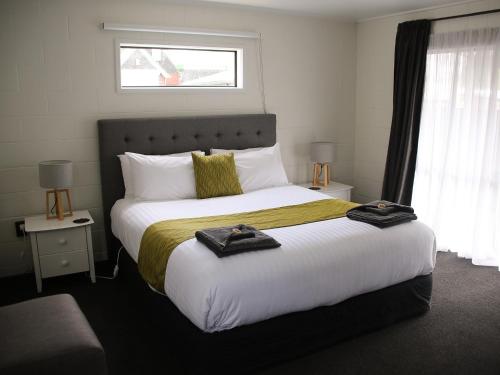 a bedroom with a large bed with towels on it at Mackenzie Motels in Fairlie