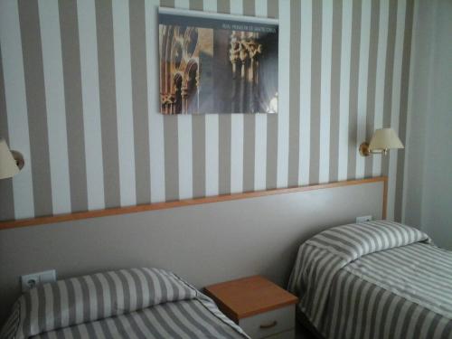 a room with two beds and a picture on the wall at Hotel Cosmos Tarragona in Tarragona