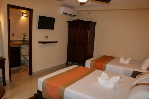 a hotel room with two beds and a television at Hotel Gayser in Valladolid