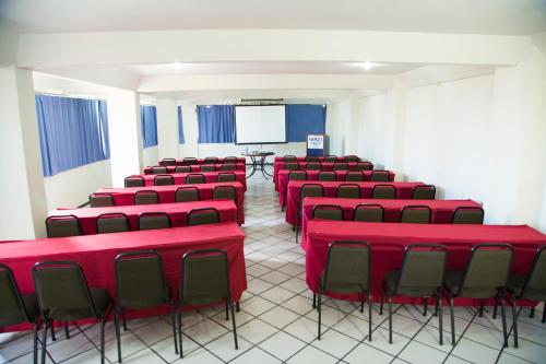 a conference room with red chairs and a screen at Monza Palace Hotel in Natal