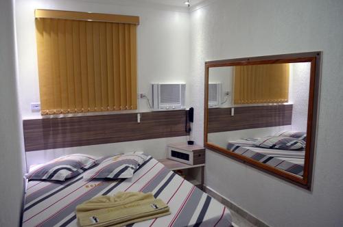 a bedroom with two twin beds and a mirror at Hotel Gold in Sao Paulo