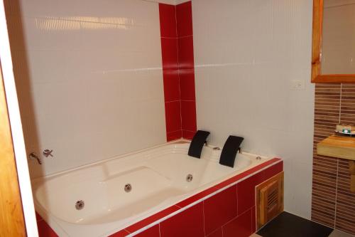 a bath tub in a bathroom with red tiles at Hotel Spa Casa de Adobe Villa de Leyva in Villa de Leyva