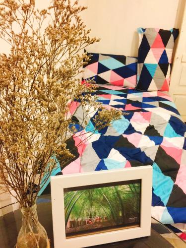 a room with a bed and a tv and flowers at Bảo Lộc Homestay in Bao Loc