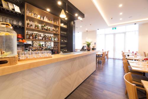 a bar in a restaurant with tables and chairs at The Sebel Auckland Manukau in Auckland
