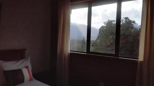 ventana de un dormitorio con vistas a la montaña en Terrazas del Palena, en La Junta
