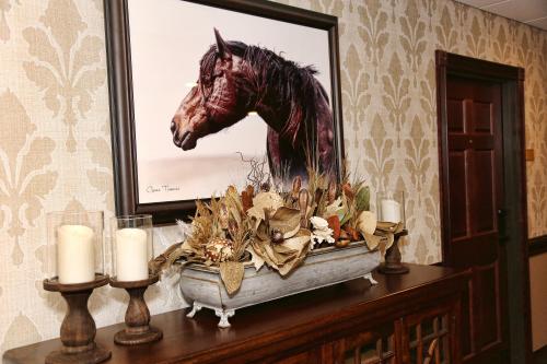 a painting of a horse on a wall with candles at Arrow Hotel in Broken Bow