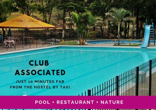 a swimming pool with a sign that says club accessible from the hospital by taxi at Hostal Encuentro in Cali