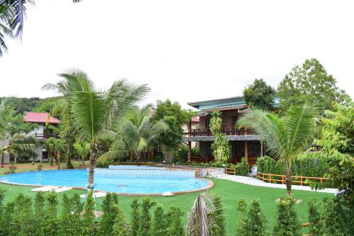 a resort with a large swimming pool and palm trees at Markhouse Bungalow Ko Kut in Ko Kood