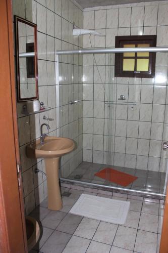 a bathroom with a shower and a sink at Pousada Flor de Paraty in Paraty