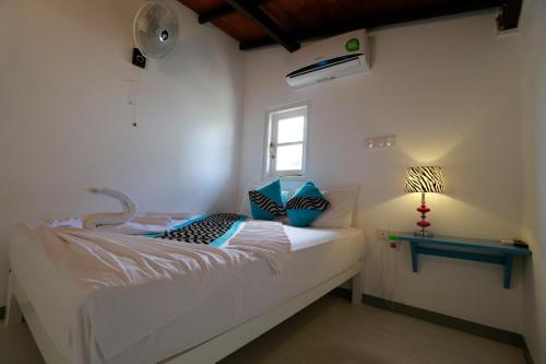 een slaapkamer met een bed, een ventilator en een raam bij Fort Heaven - Galle Fort in Galle
