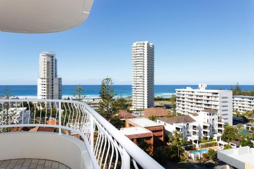 a balcony with a view of the ocean and buildings at Capricornia Apartments in Gold Coast
