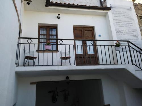 a building with a balcony with two chairs and a door at B&b barbaricino iun F1442 in Oliena