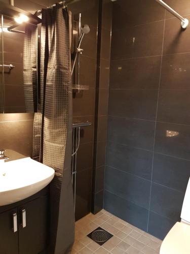 a bathroom with a shower and a sink at Apartments Uppsala - Portalgatan in Uppsala