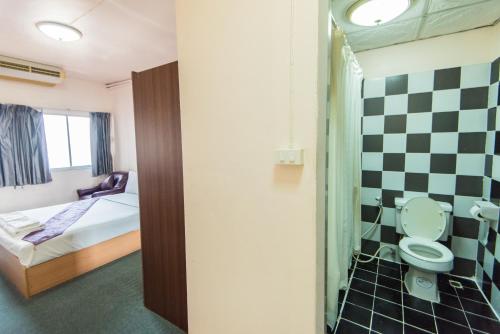 a bathroom with a bed and a toilet in a room at King Royal 2 in Bangkok