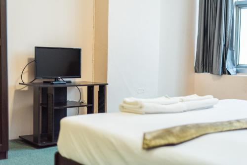a hotel room with a bed and a television at King Royal 2 in Bangkok
