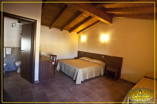 a bedroom with a bed and a bathroom with a table at Villa La Rena in Anagni