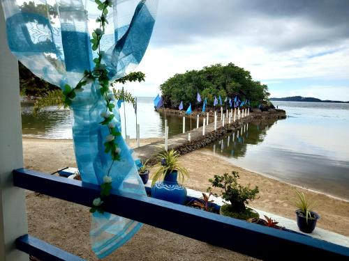 a view from a window of a beach with trees at Bolo Beach Santorini nearby to Hundred Island in Alaminos