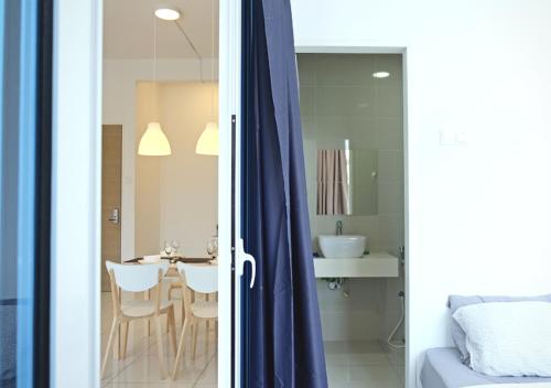 a bedroom with a bed and a bathroom with a table at Puchong Skypod Residence, 1-5 pax Cozy Unit, Walking Distance to IOI Mall, 10min Drive to Sunway in Puchong