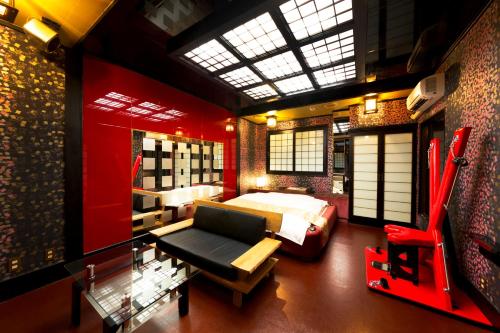 a bedroom with a bed and a couch in a room at HOTEL ABnormal (Adult Only) in Izumiotsu