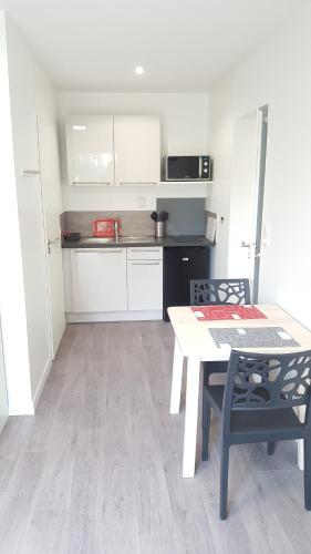 a small kitchen with a table and a table and chairs at Appartement Alouette France in Pessac