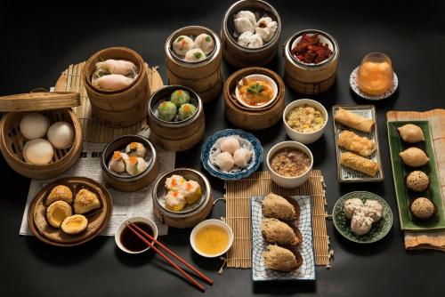 a table topped with bowls of food and plates of food at SC Park Hotel in Bangkok