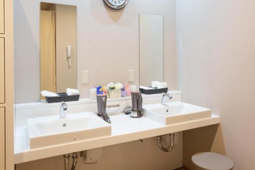 a bathroom with two sinks and a mirror at Kuretake Inn Nankai Sakai-Ekimae in Sakai
