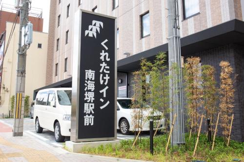 a sign on the side of a building with writing on it at Kuretake Inn Nankai Sakai-Ekimae in Sakai