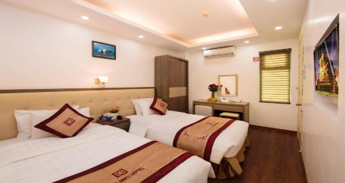 a hotel room with two beds and a window at Van Mieu Hotel in Hanoi