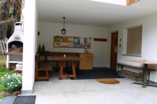 a patio with a wooden table and a stove at Ferienwohnungen Auhaus in Martello