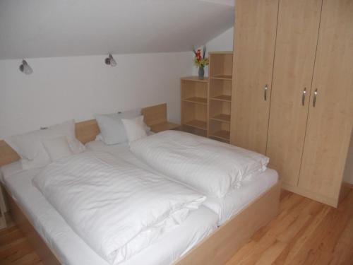 a large white bed in a room with a cabinet at Haus Hildegunde in Bad Füssing