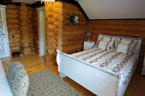 een slaapkamer met een bed in een blokhut bij Pensiunea Varvara de Bucovina in Gura Humorului