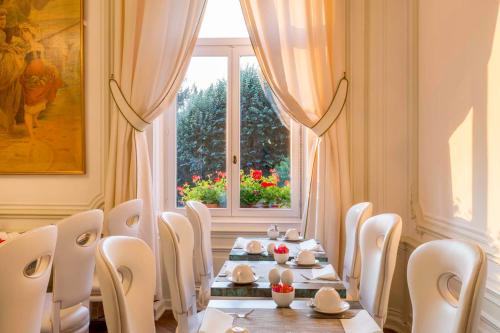 a dining room with a table and chairs and a window at Hôtel Régent Contades in Strasbourg